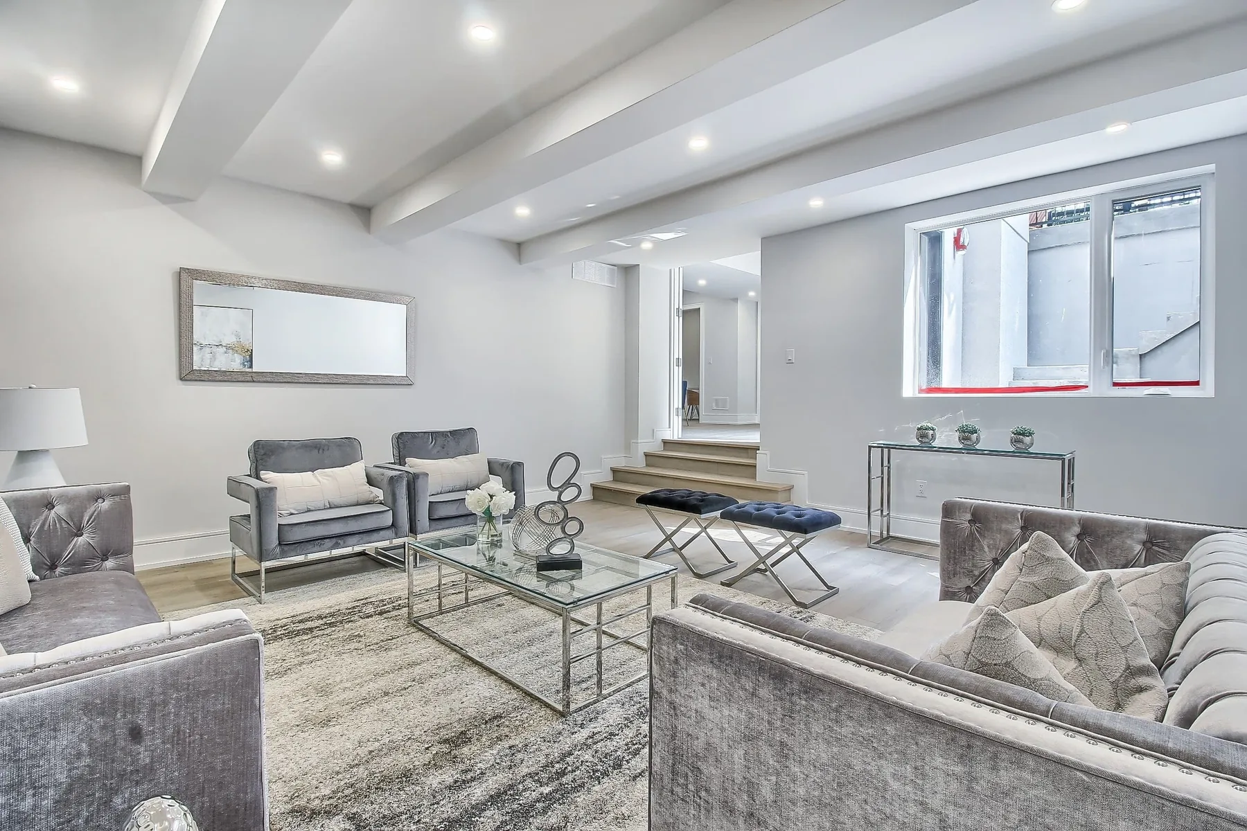 A finished lower level living space with full-height ceilings and daylight from above-grade windows